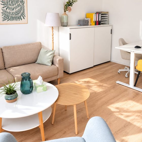 Sofaecke mit rundem Couchtisch im sonnigen Besprechungsraum
